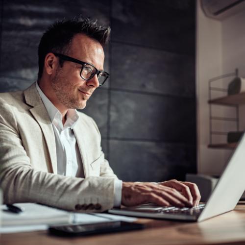 Business professional types on laptop