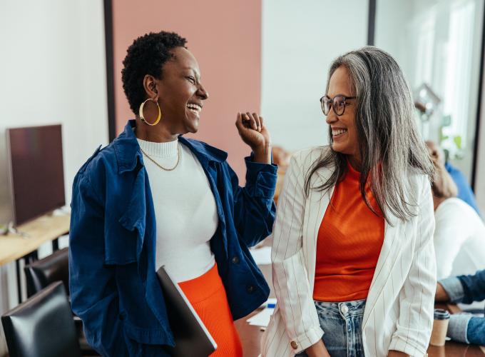 Two women at work laughing together